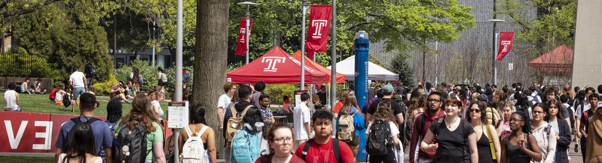 Students traveling on Temple's Main Campus on a sunny spring day